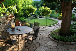 landscaping stones and flower gardens combine with wrought iron furniture for luxurious and peacful enjoyment